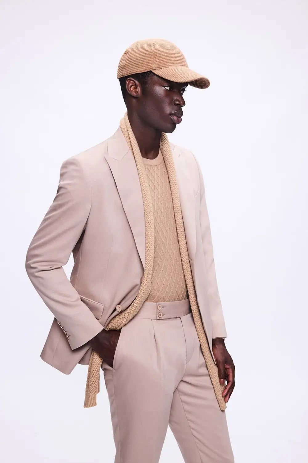 Model wearing beige suit with knit scarf