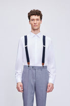Navy clip suspenders with brown leather trim and clasps designed for stylish and secure wear