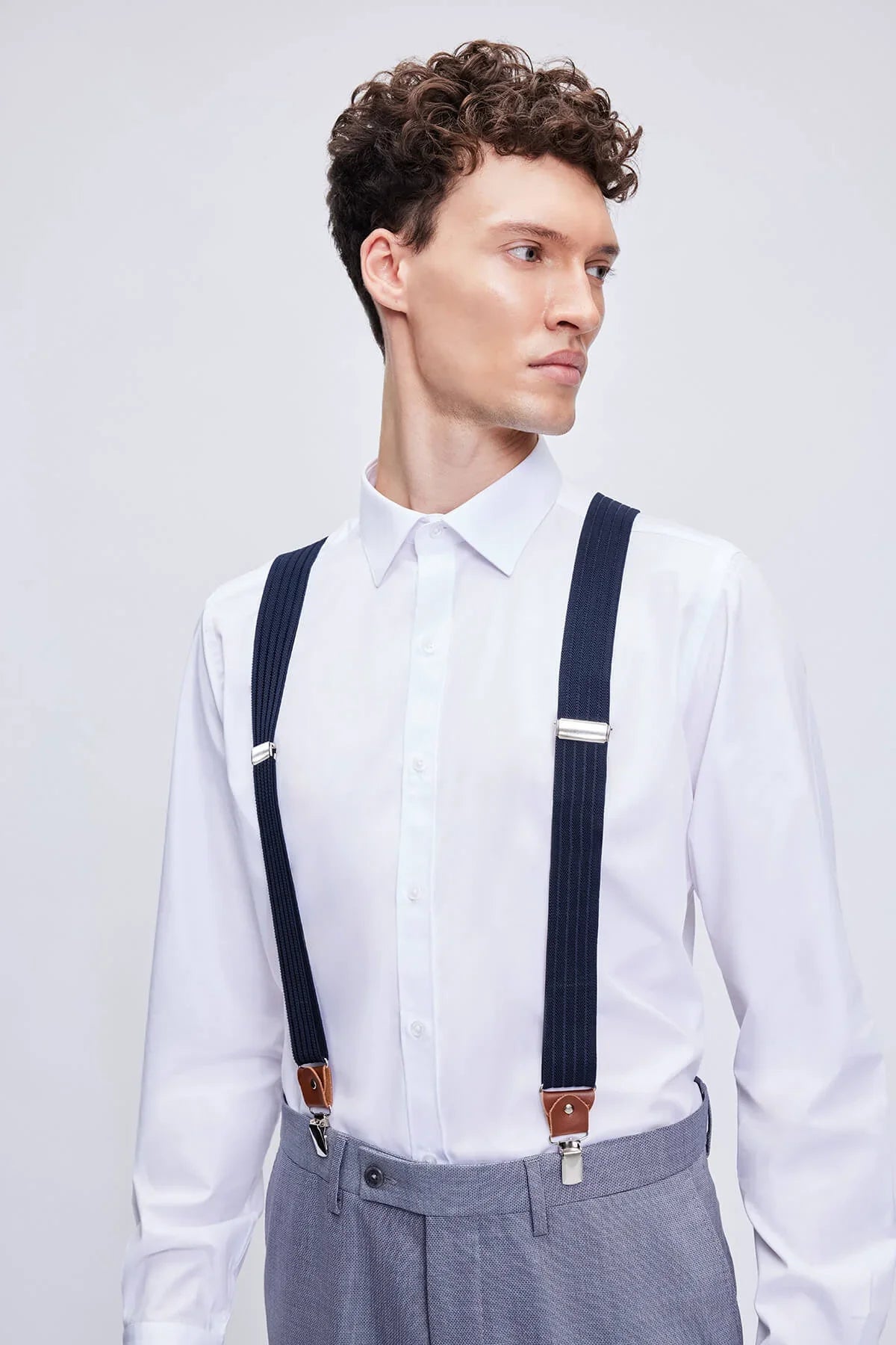 Navy clip suspenders with leather trim brown clasps and silver-toned metal hardware for stylish support