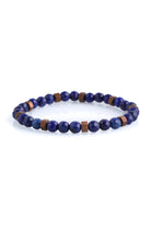 A delicate stretchy bracelet featuring alternating deep blue faceted lapis lazuli beads and small copper-toned square spacer beads.