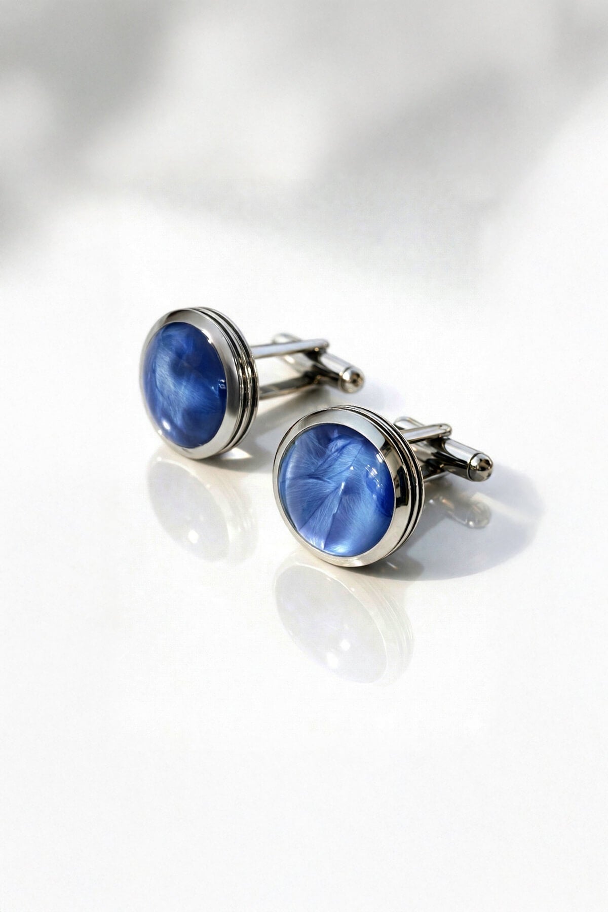 Navy natural stone round cufflinks featuring blue cat’s eye stone set in polished silver toned metal frame