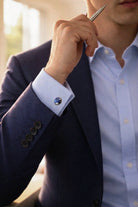 Navy natural stone round cufflinks with blue natural stone and silver-toned border on a navy suit jacket wrist