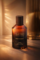 Amber glass odyssey men’s eau bottle with dark wood cap and gold lettering for men’s eau de parfum 100 ml