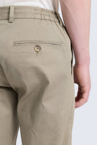 Back view of khaki olive dynamic fit jogger pants with slim fit cotton fabric elastic waistband and buttoned back pocket