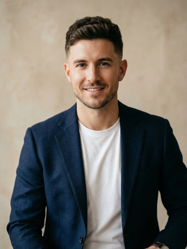 Man with an oval face shape wearing a textured crop haircut and a tailored navy blazer