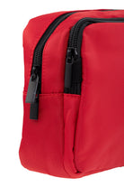Red nylon toiletry bag with black zippers and pull tabs.