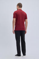 A man wearing a regular fit cotton burgundy polo t-shirt with ribbed collar and cuffs in solid red