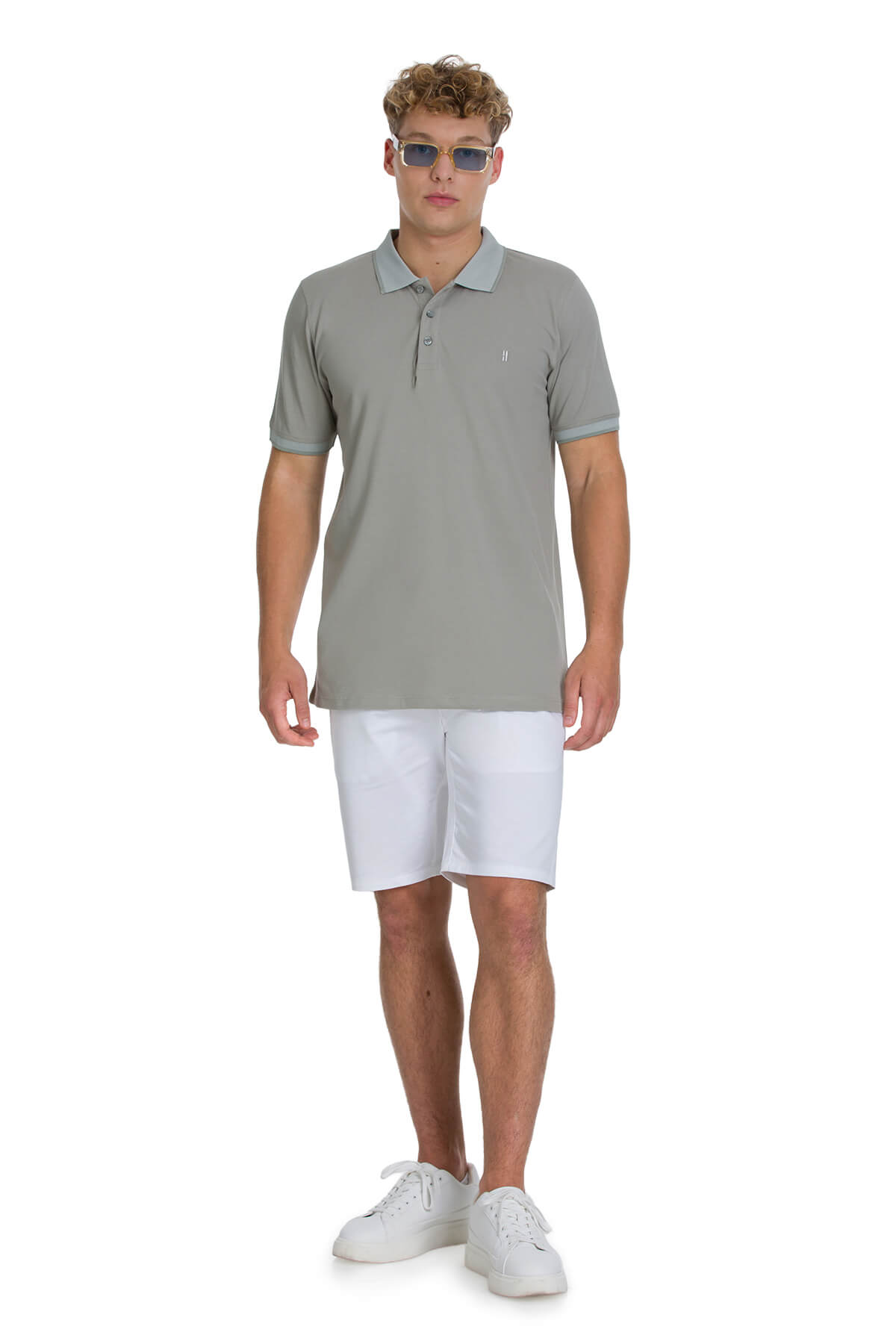 A man wearing a regular fit cotton light khaki polo shirt with a subtle logo on the chest