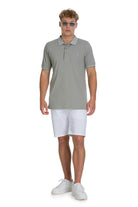 A man wearing a regular fit cotton light khaki polo shirt with a subtle logo on the chest
