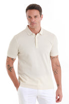 Cream-colored short-sleeved polo shirt with a classic collar and buttoned placket.