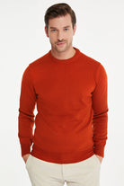 A men’s rust-orange ribbed knit sweater with a crew neckline and long sleeves.