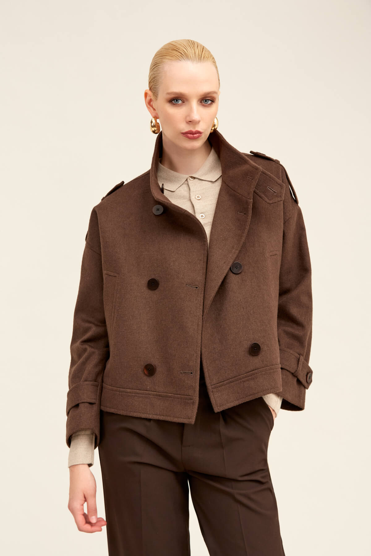 Brown double-breasted wool coat with dark buttons and structured shoulders.