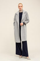 A light gray, longline coat with a subtle herringbone weave and wide lapels.