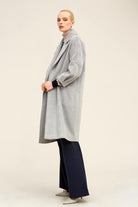 A long, light gray coat with a subtle textured pattern and wide sleeves.