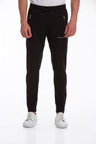 Black jogger pants with side zippers and a subtle white text logo on the left thigh.