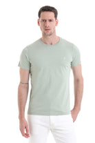 A slim-fit, light sage green cotton t-shirt with a subtle white logo on the left chest.