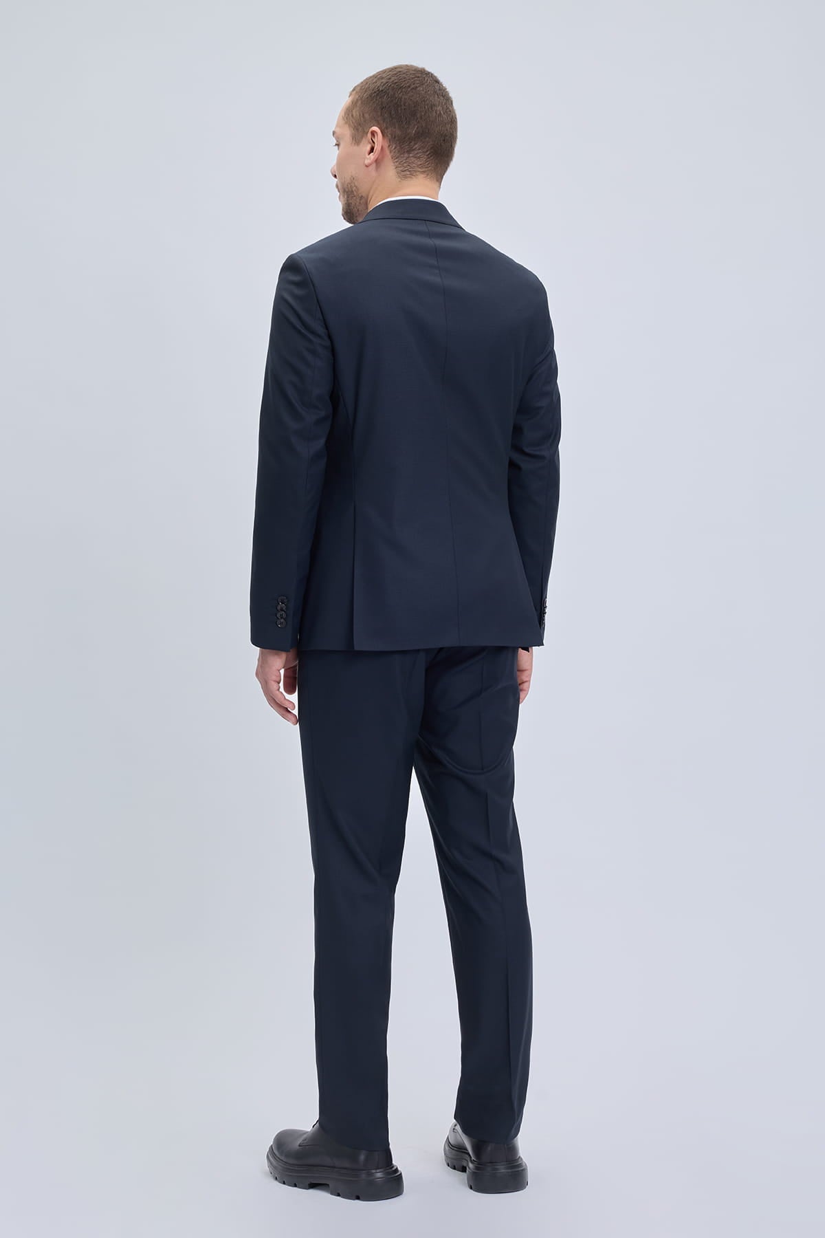 A sleek navy blue regular fit double breasted suit with peak lapel and subtle texture in classic style