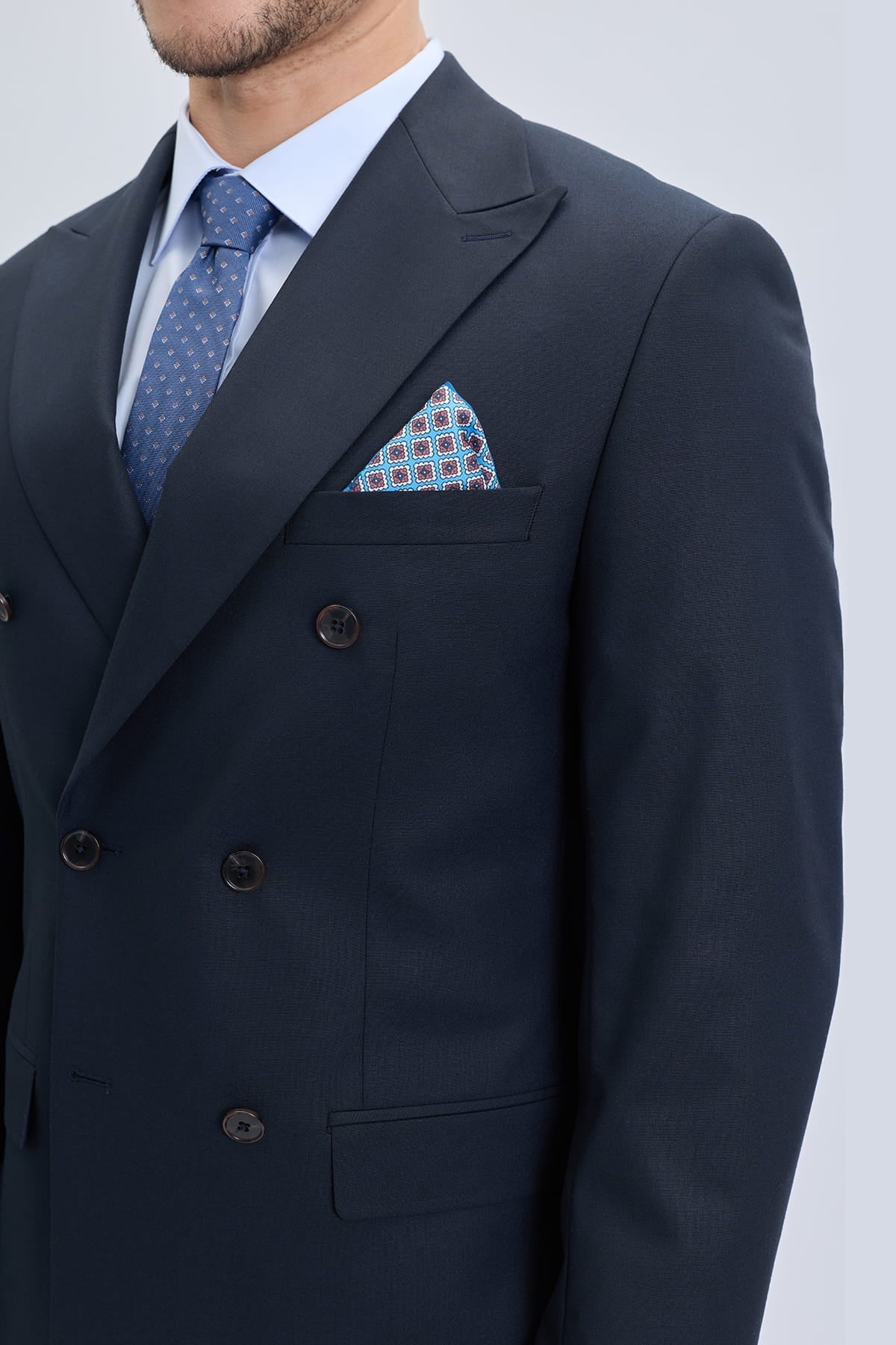 Navy blue regular fit double breasted suit jacket with peak lapel black buttons and patterned pocket square