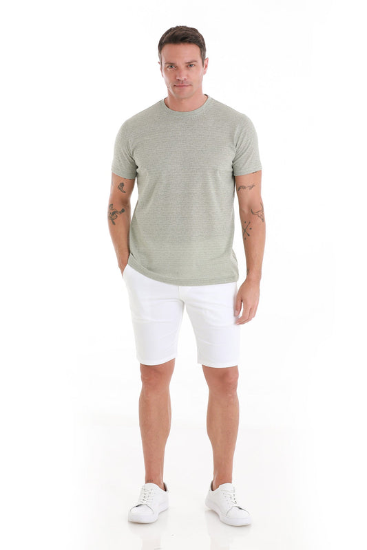 A man wearing a light green textured short-sleeve t-shirt and white shorts.