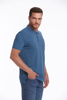 A man wearing a solid blue short-sleeved polo shirt with a classic collar and ribbed cuffs.