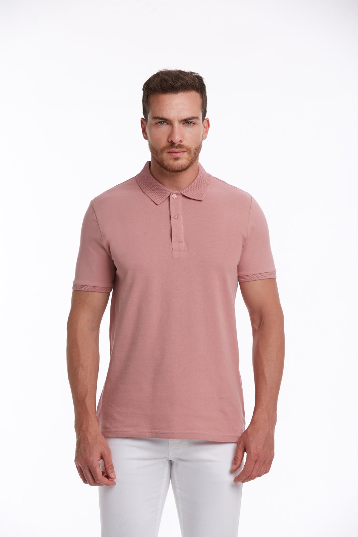 A man wearing a soft pink polo shirt with a classic collar and short sleeves.