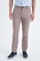 Beige cotton casual pants with regular fit, low waist, side pockets, and subtle creases in classic chino style