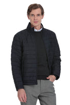 Black quilted puffer jacket with a stand-up collar and front zipper.