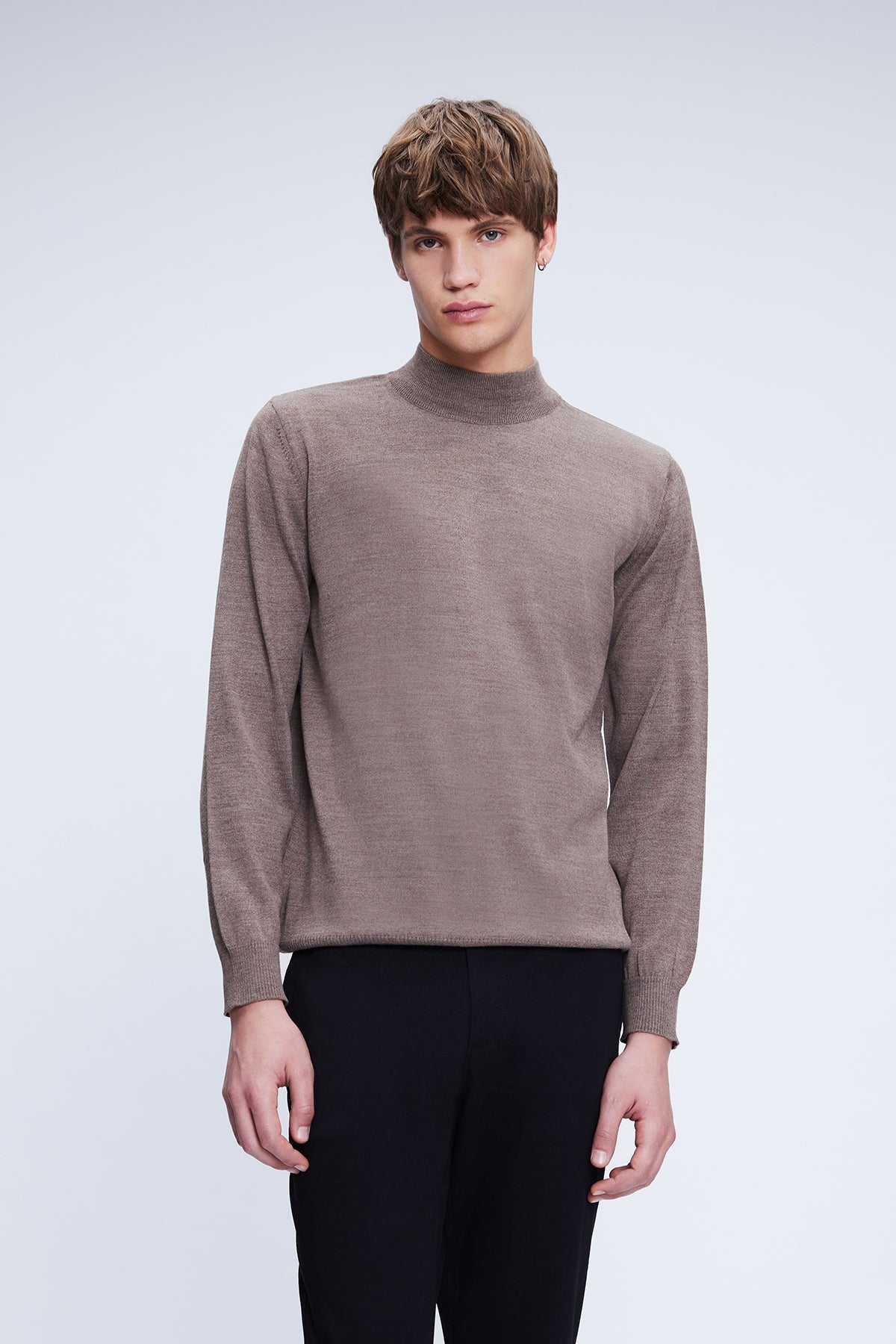 A sleek, taupe-colored turtleneck sweater with a fine knit texture and ribbed cuffs.