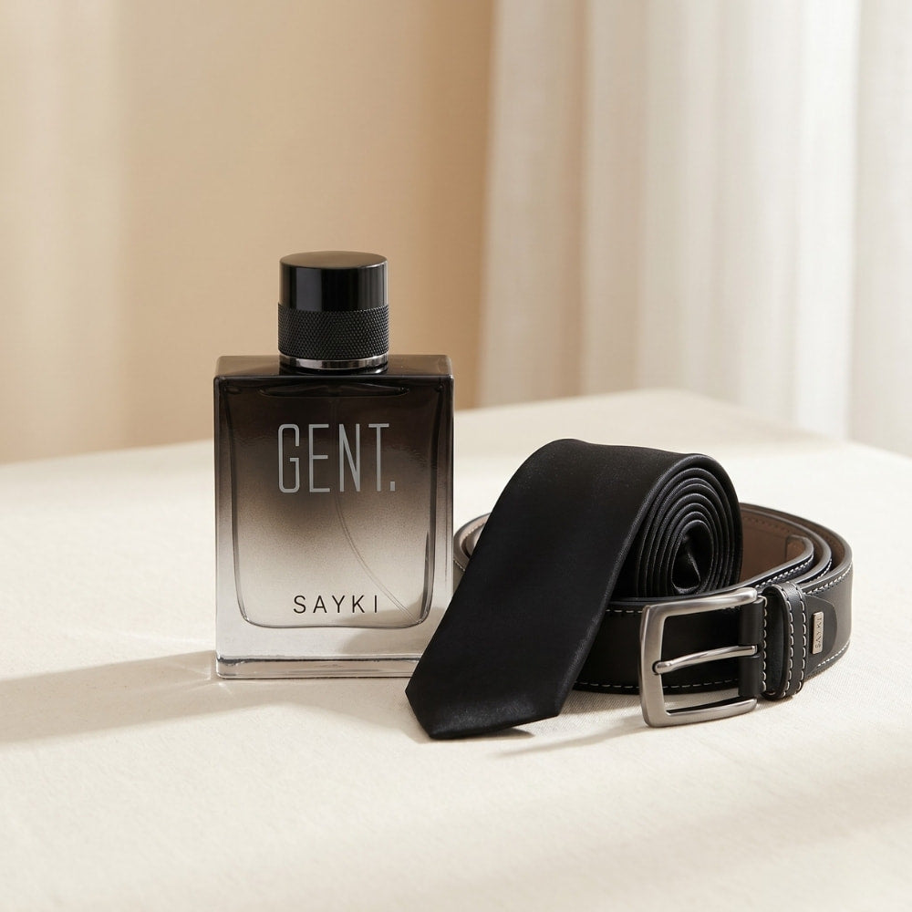 SAYKI For Him gift set with Gent fragrance, black silk tie and leather belt on a cream backdrop