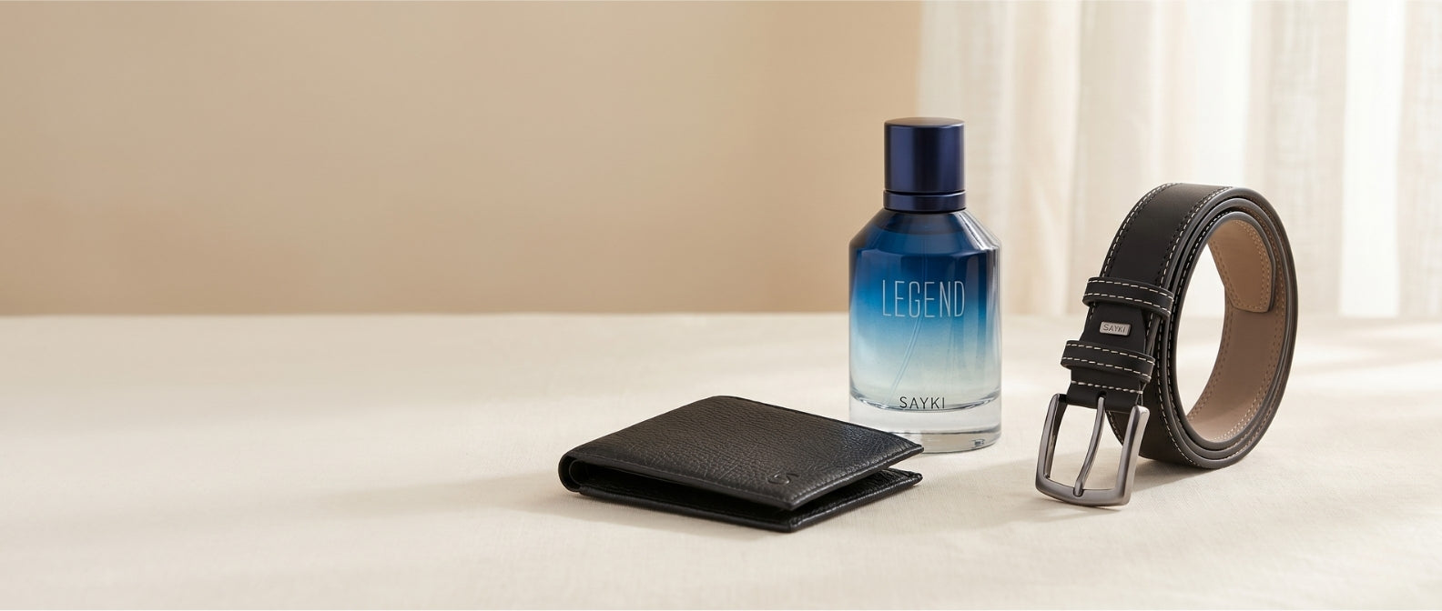 SAYKI Father's Day gift set with Legend men's fragrance, black leather wallet and belt on a cream backdrop