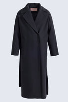 Black minimalist trench coat with structured collar and side slits from sayki woman dynamic fit collection