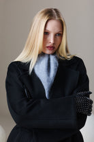 Sayki woman dynamic fit black oversized short coat with a light blue fluffy scarf draped around the neck