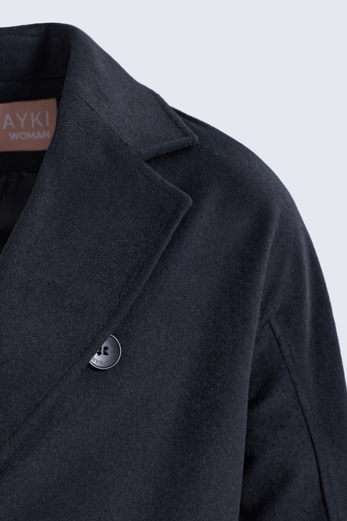 Black wool blend oversized coat with subtle texture and silver logo button by sayki woman dynamic fit double-breasted