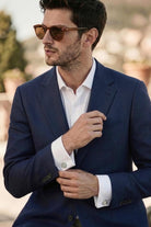 Navy blue textured wool suit jacket with white dress shirt paired with silver toned natural stone round cufflinks