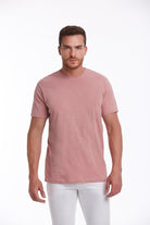 A soft blush pink, short-sleeved crew neck t-shirt made of smooth cotton fabric.
