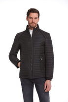 Black quilted men’s jacket with a high collar and front zipper.