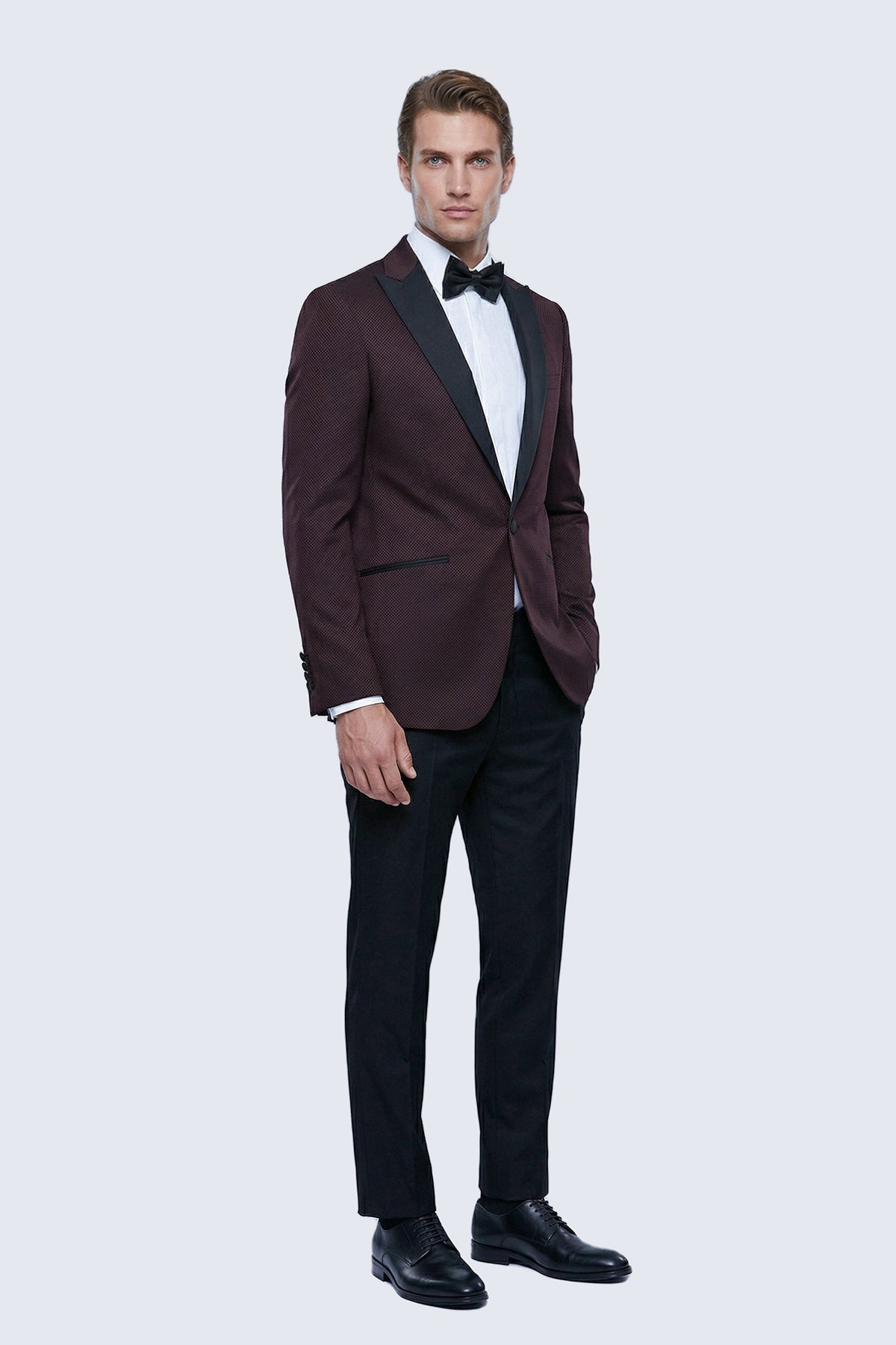 Slim fit burgundy classic tuxedo with peak lapel black satin lapels and matching black trousers for formal events