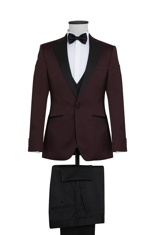 A maroon tuxedo suit with black satin lapels and matching trousers, featuring a subtle textured pattern on the jacket.