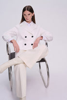 White double-breasted coat with black buttons.
