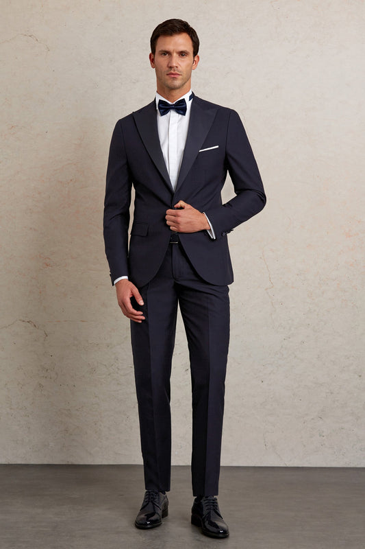 Navy blue tailored tuxedo suit with peak lapels and white pocket square