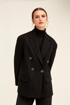 Black double-breasted blazer with circular metallic buttons.