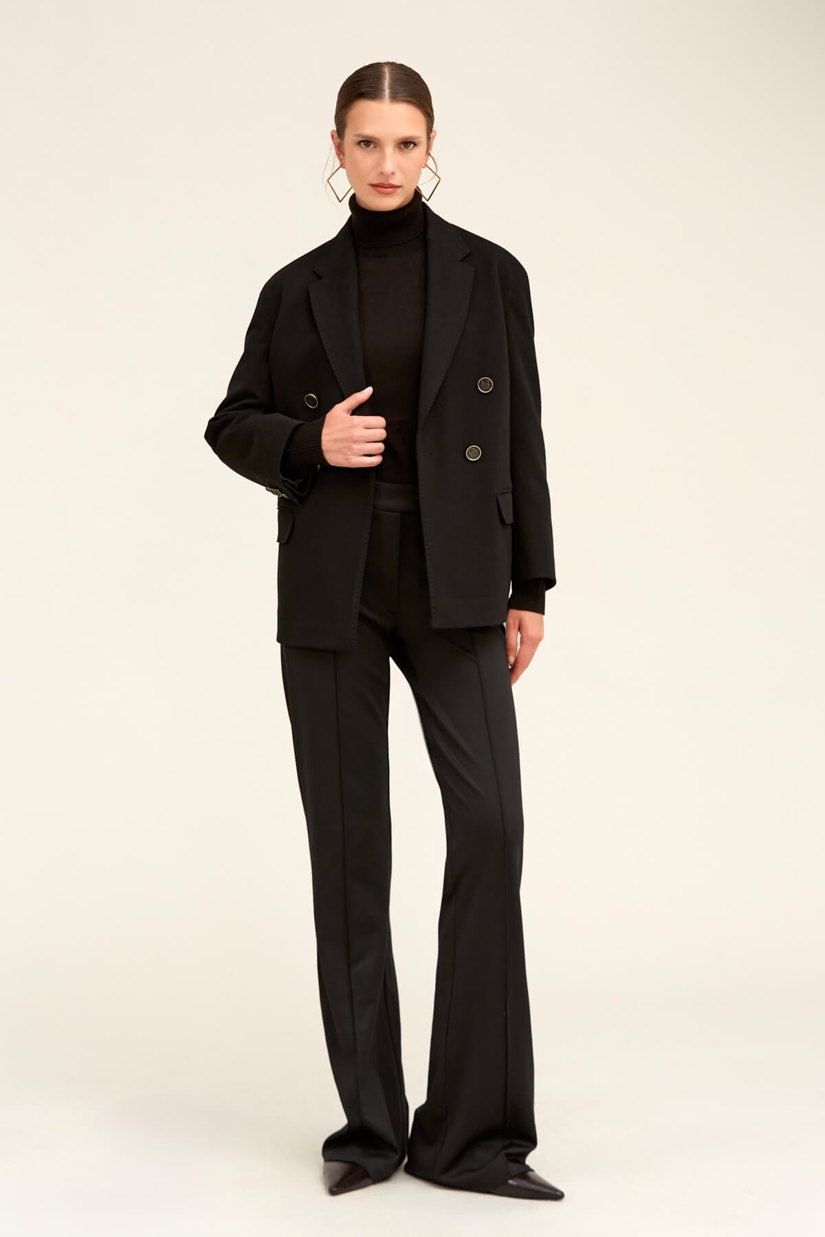 Black double-breasted blazer with structured shoulders and silver-toned buttons.