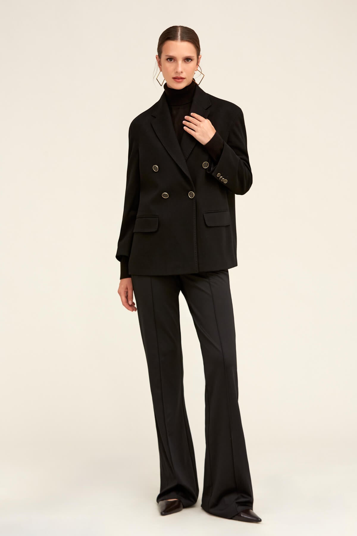 Black double-breasted blazer with structured shoulders and silver-toned buttons.