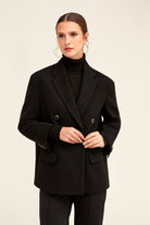 Black double-breasted blazer with structured shoulders and silver-toned buttons.