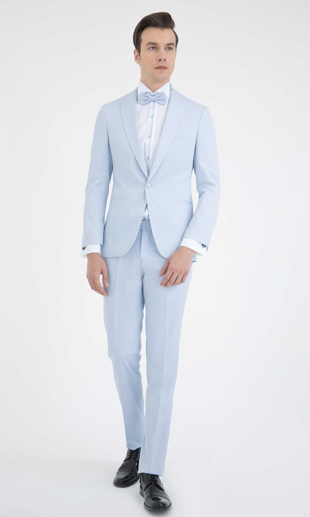 A light blue tailored suit with a matching bow tie and white dress shirt.