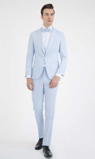 A light blue tailored suit with a matching bow tie and white dress shirt.
