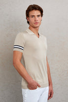 Beige short-sleeved polo shirt with black and white striped cuffs.