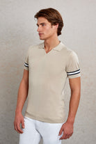 Beige short-sleeved polo shirt with black and white striped cuffs.