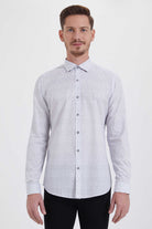A man wearing a light gray button-down shirt with a subtle white geometric pattern.