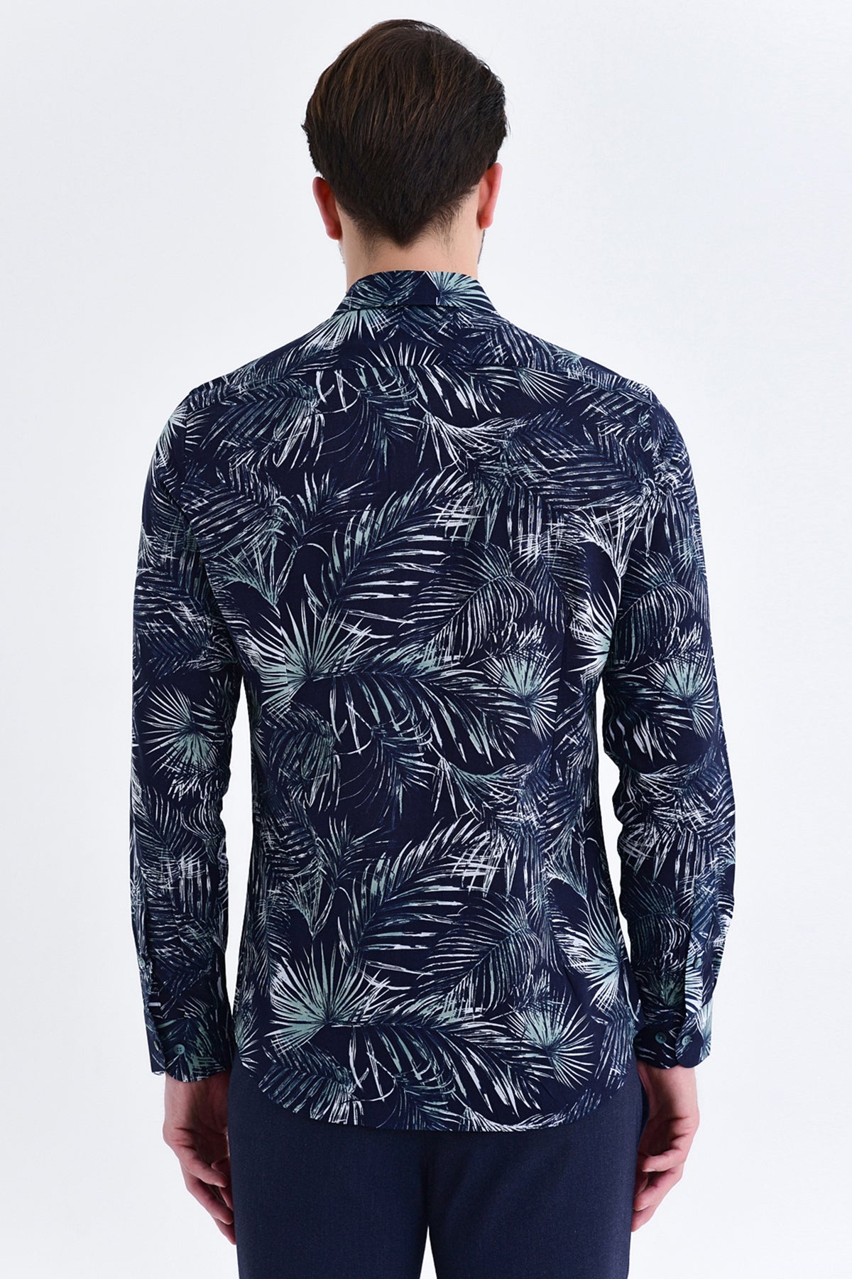 A navy blue long-sleeved shirt featuring a bold white and light green tropical leaf pattern.